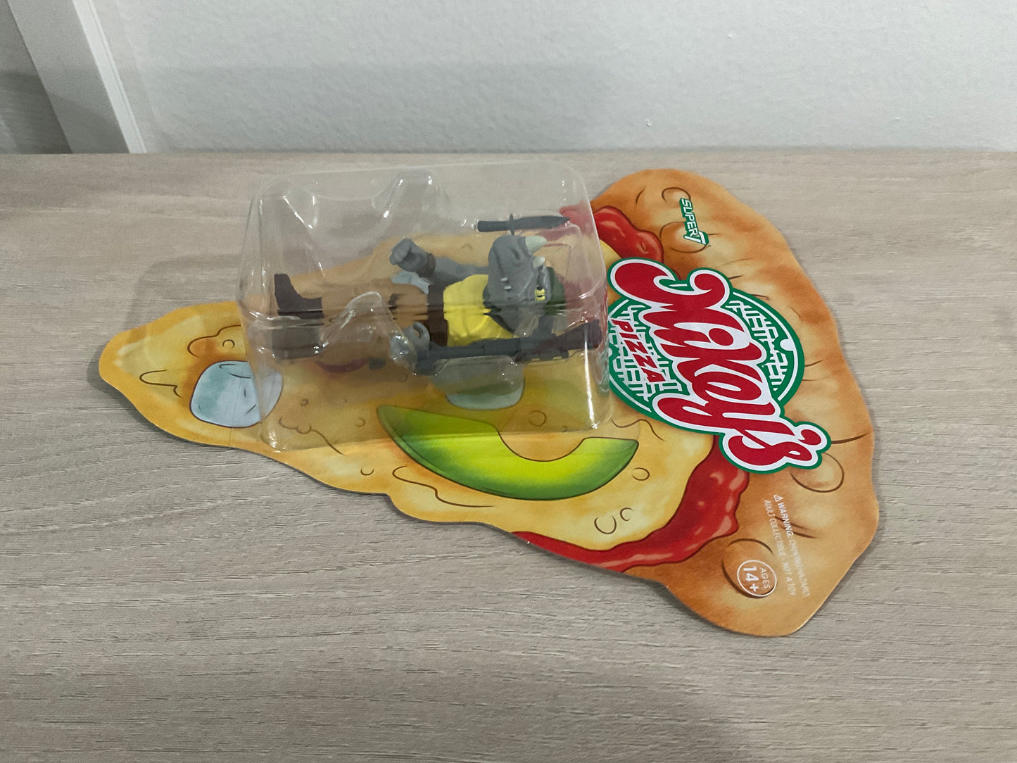 Super7 ReAction Teenage Mutant Ninja Turtles – Rocksteady “Weird Pizza To Go” 3.75-Inch Figure